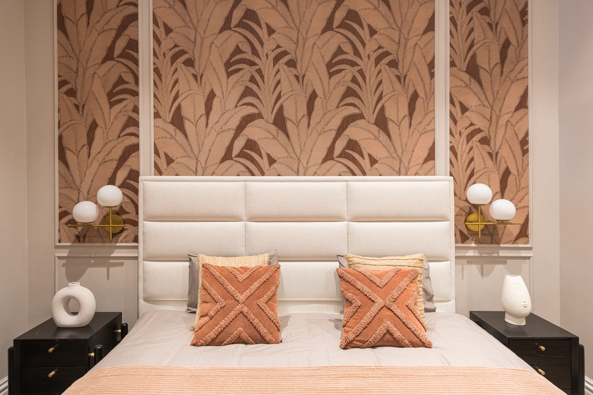 BANQA showroom living room with a bouclé sofa, sage cushions and brass wall lights
